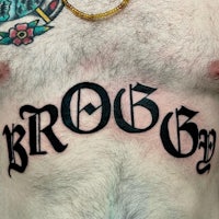 a man with a tattoo on his chest with the word brood