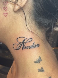 a woman's neck tattoo with the word'noraise'