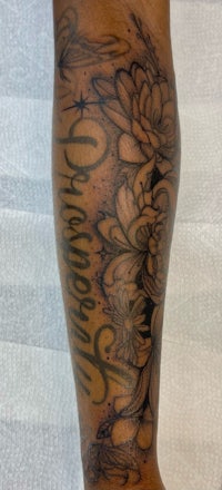 a woman's leg with a flower tattoo on it